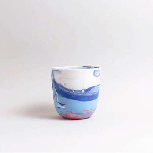 Handgefertigte Porzellan-Tasse von MK Studio mit Wellenstruktur, außen matt, innen glasiert, mit Farbverläufen aus eingefärbtem Porzellan.