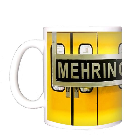 U-Bahnhof Mehringdamm Kaffeetasse - weiße Schrift auf schwarzem Schild, vor gelber Ubahn