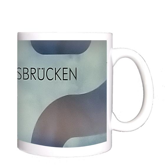 S-Bahnhof Landungsbrücken Kaffeetasse - schwarze Schrift auf blassblauem Hintergrund mit roten und blauen Schlangenlinien
