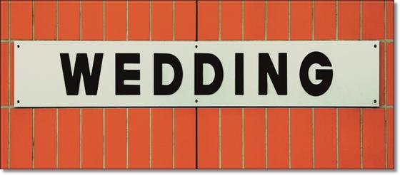 U-Bahnhof Wedding Kaffeetasse - weißes Schild mit schwarzer, schlichter Schrift auf orangen Fliesen