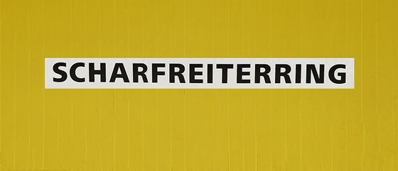 U-Bahn-Tasse Nuernberg Scharfreiterring der Linie U1 in der originalgetreuen Stations-Gestaltung - schwarze Schrift auf weißem Streifen, gelber Streifenbeton Hintergrund