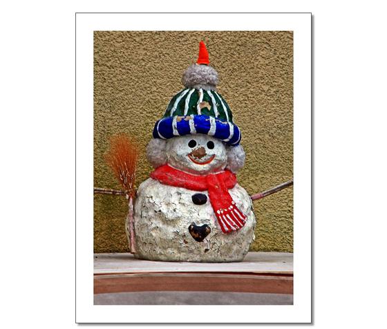 Foto-Postkarte mit weihnachtlichem Schneemann-Motiv-Kartonkarte mit weißem Rahmen - Schneemann mit abgeplatzter Farbe vor unverputzter Hauswand 