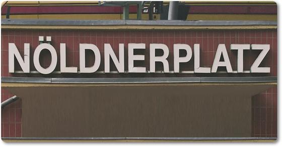 Kühlschrankmagnet mit Aufdruck der originalgetreuen Gestaltung des Außeneingangs des Berliner S-Bahnhofs Nöldnerplatz - weisse Buchstaben auf dunkelrotem fast braunen Untergrund