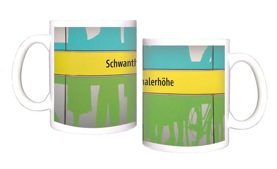 U-Bahnhof Schwanthalerhöhe Kaffeetasse - schwarze Schrift auf gelbem Streifen, zwischen grünem und blauem Querstreifen mit abstrakten Mustern