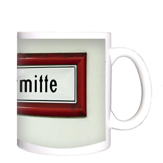 U-Bahnhof Stadtmitte Kaffeetasse - schwarze Schrift auf weißem Schild, mit rotem dickem Rahmen, vor weißer Wand