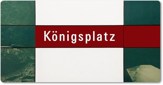 U-Bahnhof Königsplatz Kühlschrankmagnet - weiße Schrift auf dunkelrotem Streifen, vor dunkelgrüner Fotowand mit Kristallen, durchbrochen von einem weißen, senkrechten Rechteck