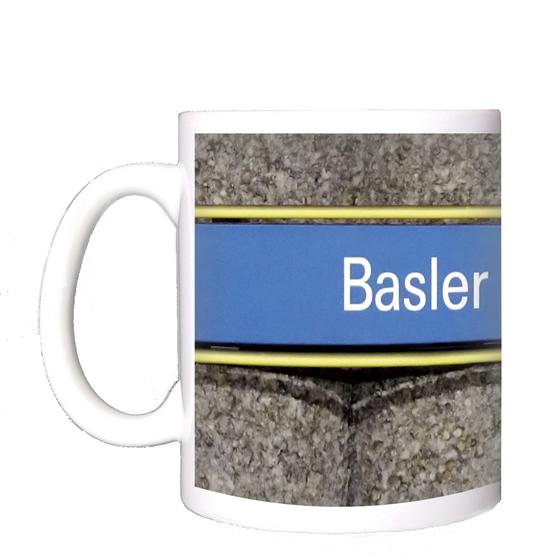 U-Bahnhof Basler Straße Kaffeetasse - weiße Schrift auf hellblauem Schild, gelb umrandet, vor grauer Säulenwand