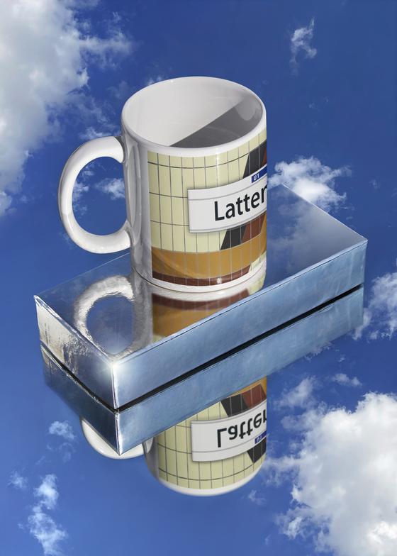 S-Bahn Hamburg Kaffeebecher Kaffeetasse S-Bahnhof Lattenkamp beige Fliesen mit orang, rot gelbem Muster, darüber weißes Schild mit schwarzer Schrift tom bäcker, Geschenkidee, 