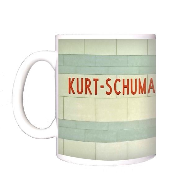 U-Bahnhof Kurt-Schumacher-Platz Kaffeetasse - rote Schrift auf weißen Kacheln mit hellblauen Querstreifen