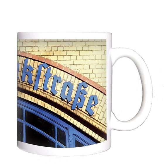 S-Bahnhof Wollankstraße Kaffeetasse - blauer, gebogener Schriftzug in Frakturschrift auf rötlichem Klinkerstein