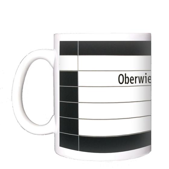 U-Bahnhof Oberwiesenfeld Kaffeetasse - schwarze Schrift auf weißem Untergrund, mit schwarzer Umrandung und grauen Querfugen