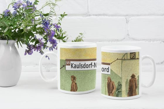 U-Bahnhof Kaulsdorf-Nord Kaffeetasse, schwarze Schrift auf weißem Streifen über gelb grünem Hintergrund mit braunen Siluetten von Menschen