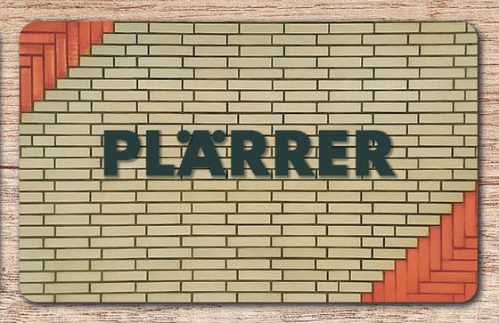 U-Bahn-Brettchen Nuernberg Plaerrer der Linien U1, U2 und U3 in der originalgetreuen Stations-Gestaltung mit dunkle Buchstaben auf beigen Fliesen - in den Ecken noch orangene Kacheln, welche in der Gesamtoptik einen Pfeil bilden