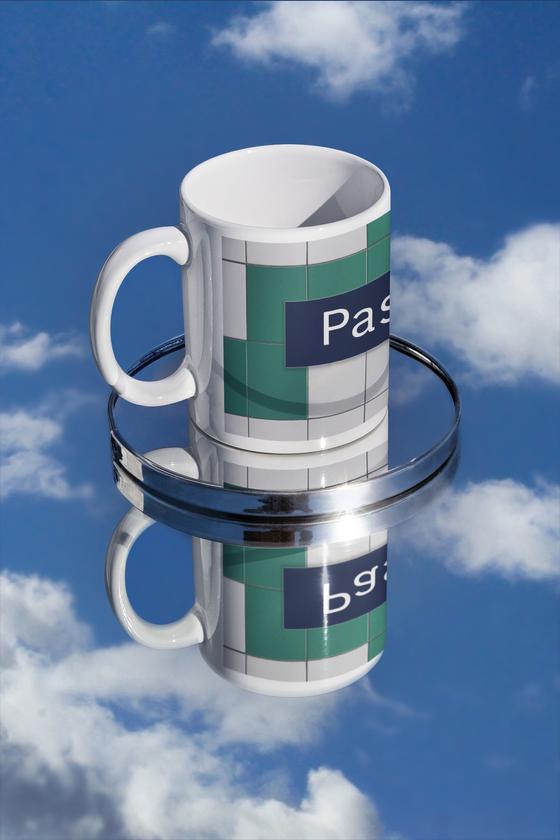 S-Bahnhof Pasing Kaffeetasse - dunkelblaues S-Bahnschild mit weißer, serifenloser Schrift, vor weißer Fliesenwand mit vereinzelten grünen Fliesen