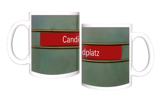 U-Bahnhof Candidplatz Kaffeetasse - weiße Schrift, auf rotem Streifen, schwarz umrandet, vor grauem Untergrund