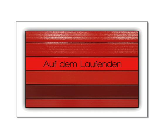 Postkarte in Ubahnstationsschild-Optik - gestreifte Gleisrückwand in verschiedenen Rottönen, darauf zentral in schwarzer Schrift "Auf dem Laufenden"
