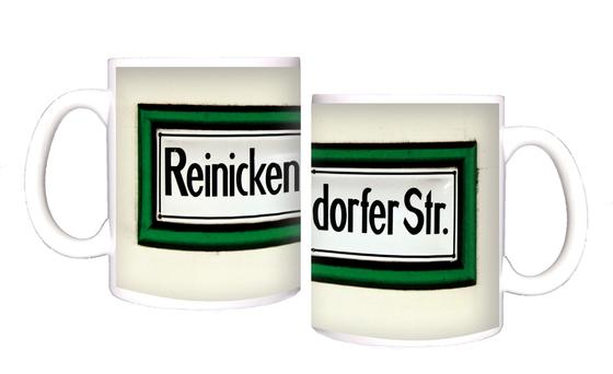 U-Bahnhof Reinickendorfer Straße Kaffeetasse - schwarze Schrift auf weißem Schild, mit dickem, grünem Rahmen, vor weißer Wand