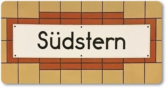 U-Bahnhof Südstern Kühlschrankmagnet - weißes Schild mit schwarzer, schlichter Schrift auf weißem Schild mit rötlich-brauner Umrandung auf orange-gelben Fliesen