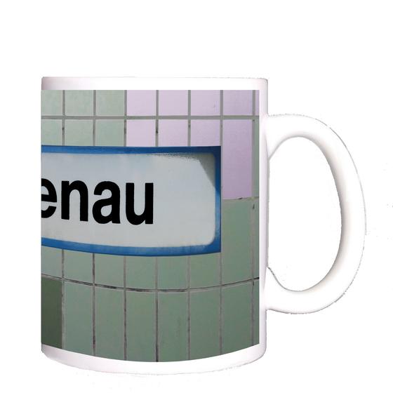 S-Bahnhof Eichenau Kaffeetasse - weißes Schild mit schwarzer Schrift und hellblauer Umrandung, auf Fliesenwand in zwei Grüntönen und weißen Fliesen