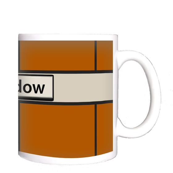 U-Bahn-Tasse Berlin Rudow der Linie U7 in der originalgetreuen, historischen Stations-Gestaltung mit orangener Wandverkleidung und weissem Balken mit schwarzer Schrift