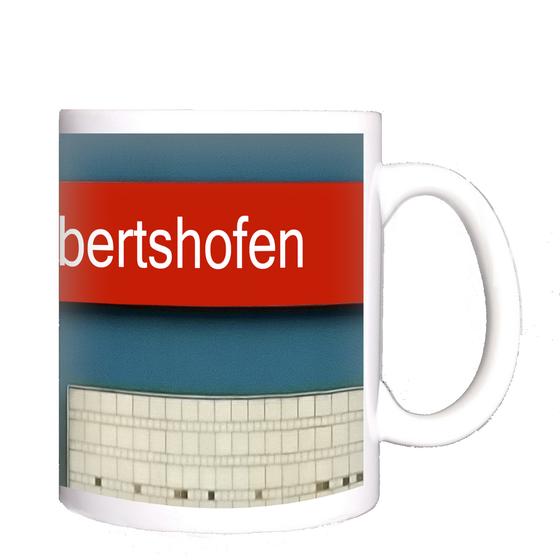 U-Bahnhof Milbertshofen München Kaffeetasse - rotes Schild,mit weißer Schrift auf blauem Untergrund mit rotem Streifen und weißer Tafel mit Muster in der rechten unteren Ecke