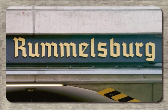 S-Bahnhof Rummelsburg - Frakturschrift in beige auf einem dunklen Schild weitere helle Streifen - Ansicht Tasse links und rechts