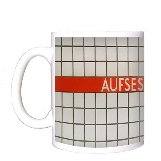 U-Bahn-Tasse Aufsessplatz der Nuernberger Linie U1 in der originalgetreuen Stations-Gestaltung - weiße Schrift auf rot-orangem Streifen mit weißen Kachelhintergrund 