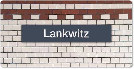 Kühlschrankmagnet mit Aufdruck der originalgetreuen Gestaltung des Berliner S-Bahnhofs Lankwitz - blaues S-Bahn-Schild mit weisser Schrift auf weissem Fliesenuntergund, oben zwei Reihen als kontrastierende Bordüre in rost-rot-braun