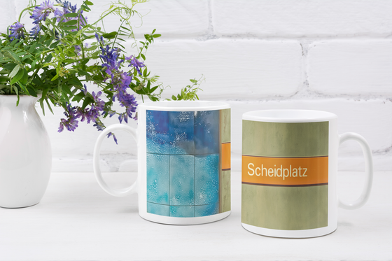 U-Bahnhof Scheidplatz Kaffeetasse - weiße Schrift auf orangem Streifen, vor braun-beiger Wand mit blauen Fliesen am linken Rand
