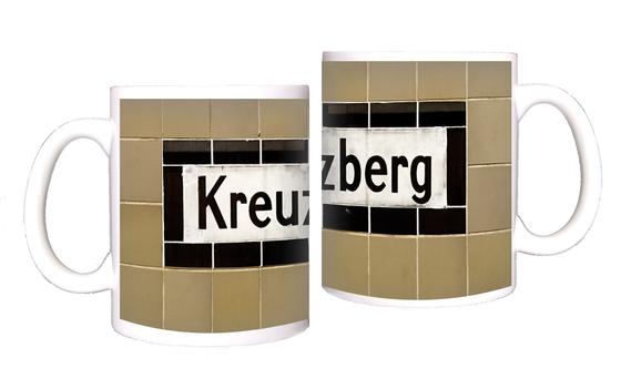 U-Bahnhof Kreuzberg - weißes Schild mit schwarzer Schrift und schwarzem Rand, vor beige-braunen Kacheln