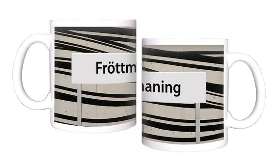 U-Bahnhof Fröttmaning Kaffeetasse - schwarze Schrift auf weißem Schild, vor weißem Hintergrund mit dynamischen, schwarzen Streifen