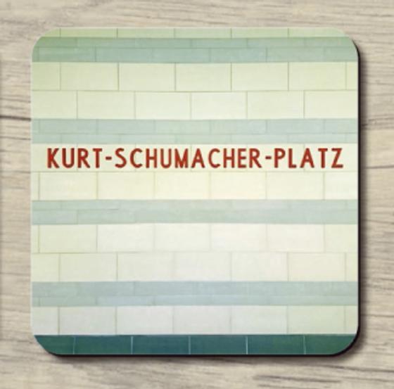 U-Bahnhof Kurt-Schumacher-Platz - rote Schrift auf Hintergrund aus Fliesen in hellblau und weiß gestreife
