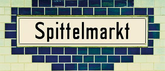 U-Bahnhof Spittelmarkt Kaffeetasse - weißes Schild mit schwarzer Schrift auf rautenförmigem, dunkelblauem Fliesenhintergrund, umrandet von weißen Fliesen