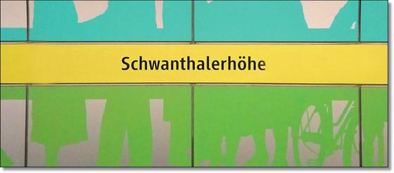 U-Bahnhof Schwanthalerhöhe Kaffeetasse - schwarze Schrift auf gelbem Streifen, zwischen grünem und blauem Querstreifen mit abstrakten Mustern
