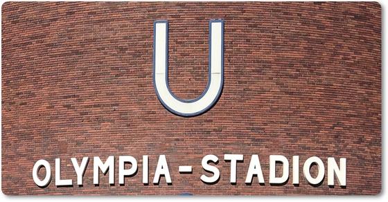 U-Bahnhof Olympia-Stadion - weißer Schriftzug unter weißem "U" auf rot-brauner Backsteinwand