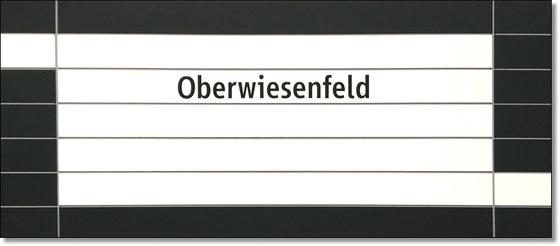 U-Bahnhof Oberwiesenfeld Kaffeetasse - schwarze Schrift auf weißem Untergrund, mit schwarzer Umrandung und grauen Querfugen