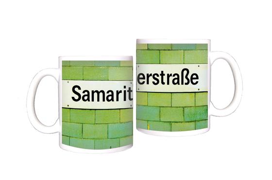 U-Bahnhof Samariterstraße Kaffeetasse - schwarzes Schild mit weißer Schrift auf grün-gelber Fliesenwand