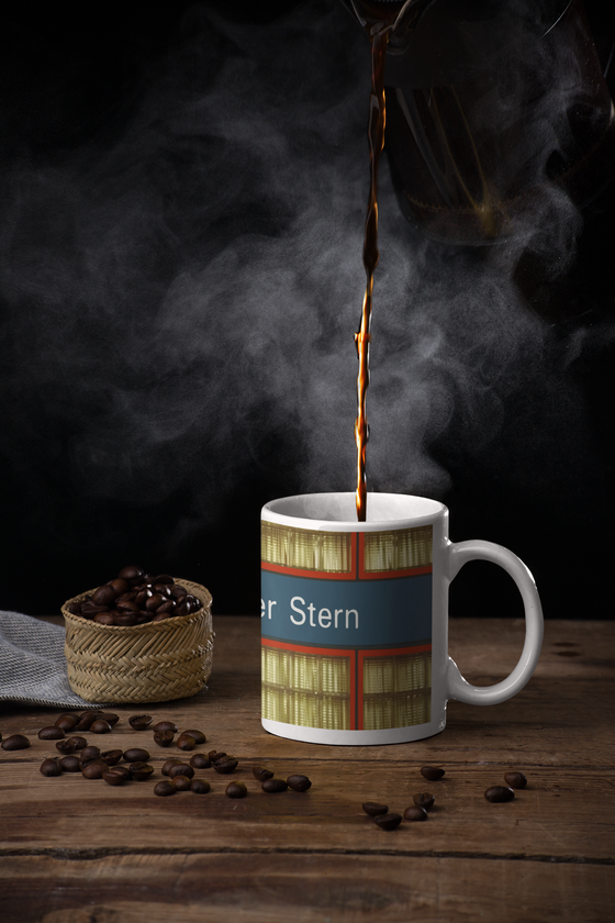 U-Bahnhof Haderner Stern Kaffeetasse - weiße Schrift auf blauem Schild, rot umrandet, vor gelblichen, quadratischen Glasscheiben