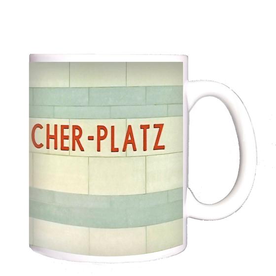 U-Bahnhof Kurt-Schumacher-Platz Kaffeetasse - rote Schrift auf weißen Kacheln mit hellblauen Querstreifen