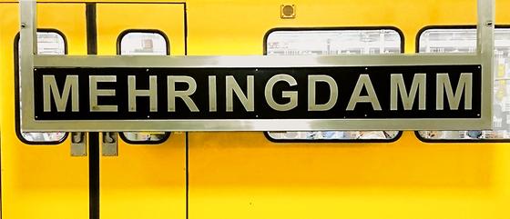 U-Bahnhof Mehringdamm Kaffeetasse - weiße Schrift auf schwarzem Schild, vor gelber Ubahn