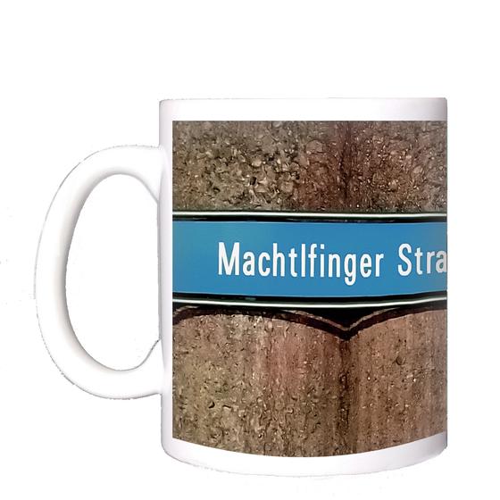 U-Bahnhof Machtlfinger Strasse Kaffeetasse - weiße Schrift auf blauem Schild, vor Betonsäulen-Wand mit pinkem Streifen