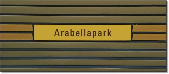 U-Bahnhof Arabellapark Kaffeetasse - schwarze Schrift auf gelbem Streifen, auf blau-braunen Lamellen