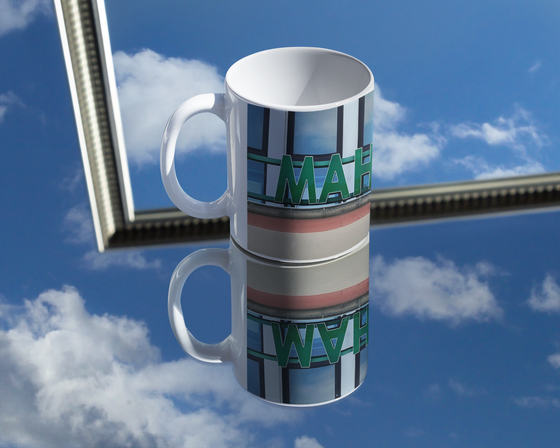 S-Bahnhof Mahlow Kaffeetasse grüne Schrift auf Bahnhofgebeude mit Fenstern dahinter
