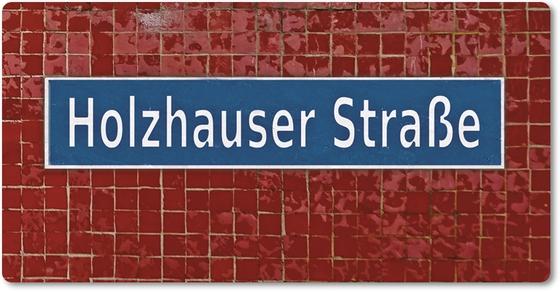 U-Bahnhof Holzhauser Straße - weiße Schrift auf blauem Schild mit weißer Rahmung auf dunkelroten Fließen