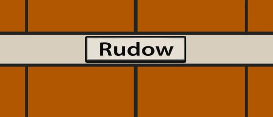 U-Bahn-Tasse Berlin Rudow der Linie U7 in der originalgetreuen, historischen Stations-Gestaltung mit orangener Wandverkleidung und weissem Balken mit schwarzer Schrift