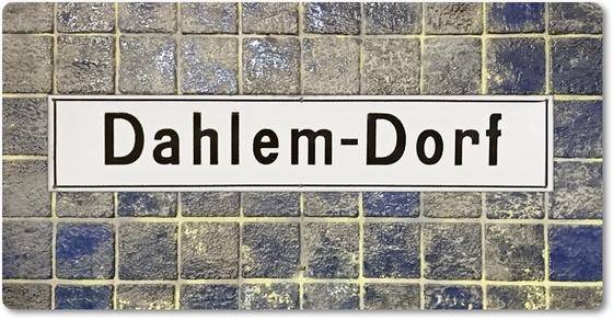 U-Bahnhof Dahlem-Dorf -  schwarze Schrift auf traditionellem, weißen Emailleschild auf blau-grau changierenden kleinen quadratischen Kacheln