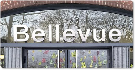 S-Bahnhof Bellevue weise Schrift auf grauem Balken über Glastüreingang