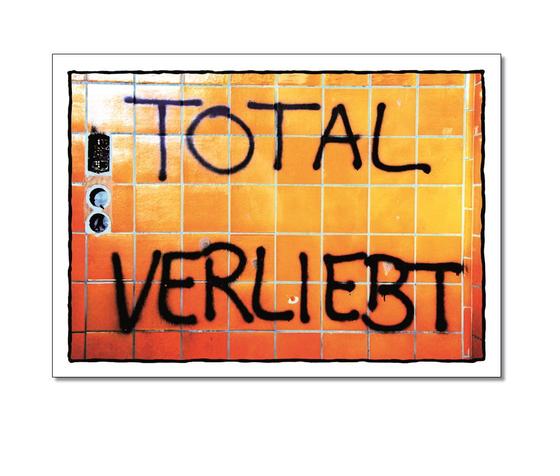 Klassische Postkarte - Ganzkoerperkribbeln. Foto einer Wand, auf welche Total Verliebt gesprueht wurde. 