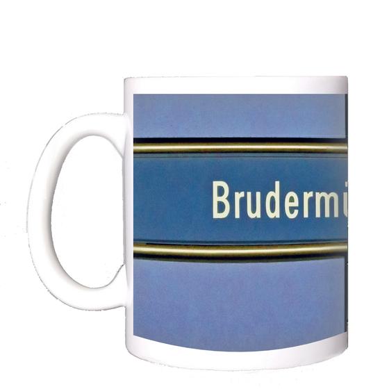 U-Bahnhof Brudermühlstraße Kaffeetasse - weiße Schrift auf blauem Schild, gelb umrandet, vor fliederfarbenem Untergrund