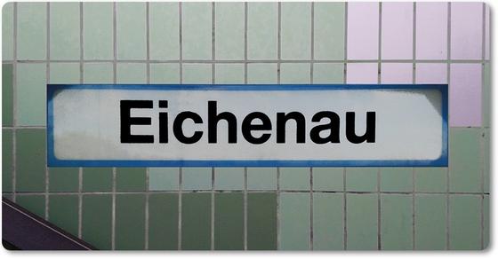 S-Bahnhof Eichenau Kühlschrankmagnet - weißes Schild mit schwarzer Schrift und hellblauer Umrandung, auf Fliesenwand in zwei Grüntönen und weißen Fliesen
